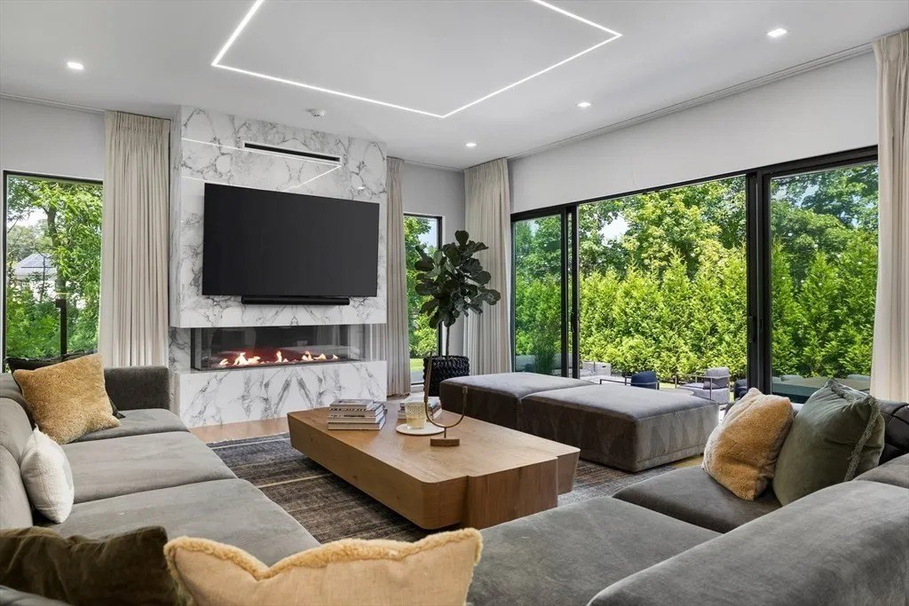 NBA Star Jrue Holiday Lists His Massachusetts Home For $6.9 Million—Weeks After Portland Trail Blazers Living space with a fireplace in a luxury home in Massachusetts that belongs to Jrue Holiday